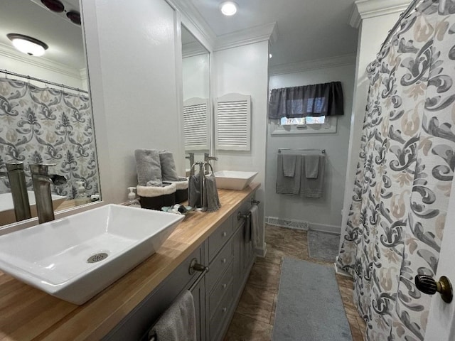 bathroom with vanity, ornamental molding, and walk in shower