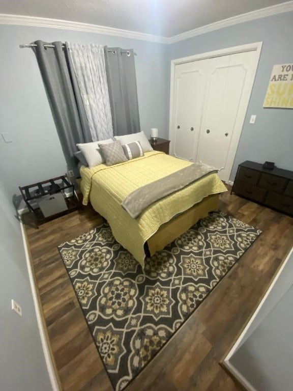 bedroom featuring crown molding, a closet, and dark hardwood / wood-style floors