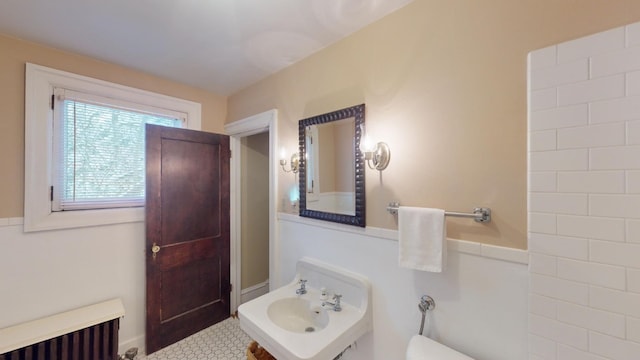 bathroom with toilet, radiator heating unit, and sink