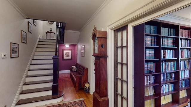 stairway featuring wood-type flooring and ornamental molding