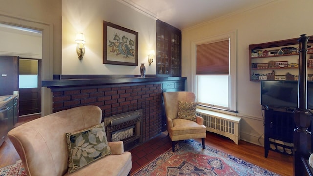 sitting room with radiator, dark hardwood / wood-style floors, and ornamental molding