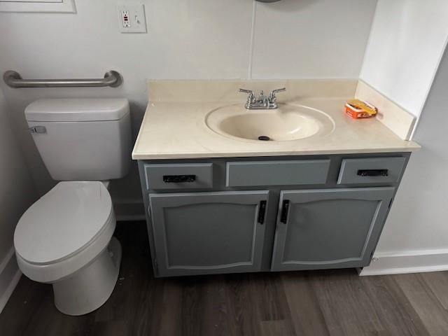 bathroom with toilet, vanity, and wood finished floors