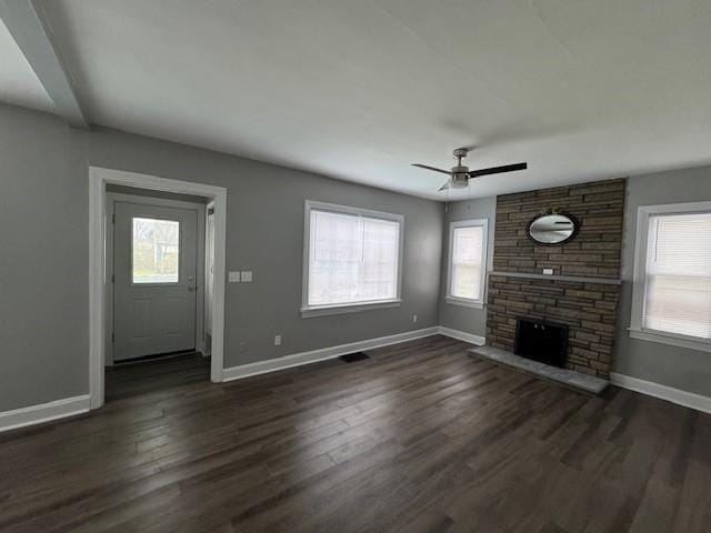 unfurnished living room featuring a fireplace, baseboards, ceiling fan, and dark wood-style floors