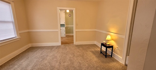 empty room featuring carpet and baseboards