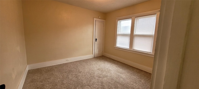 empty room with carpet floors and baseboards