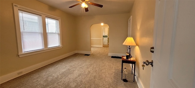 interior space featuring arched walkways, visible vents, ceiling fan, and baseboards