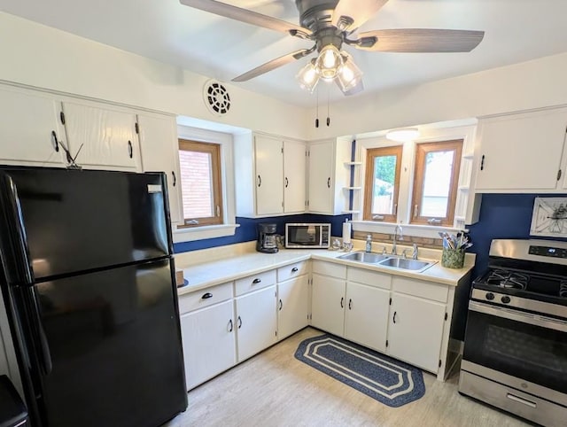 933 E 31st St, Erie, PA 16504 - kitchen with appliances with stainless steel finishes, light countertops, light wood-style floors, and white cabinets