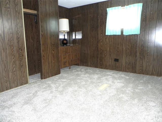 empty room with carpet and wooden walls