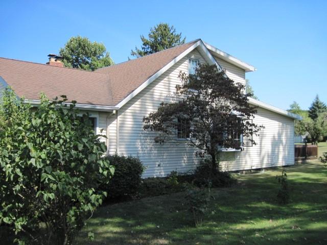 view of side of home with a yard