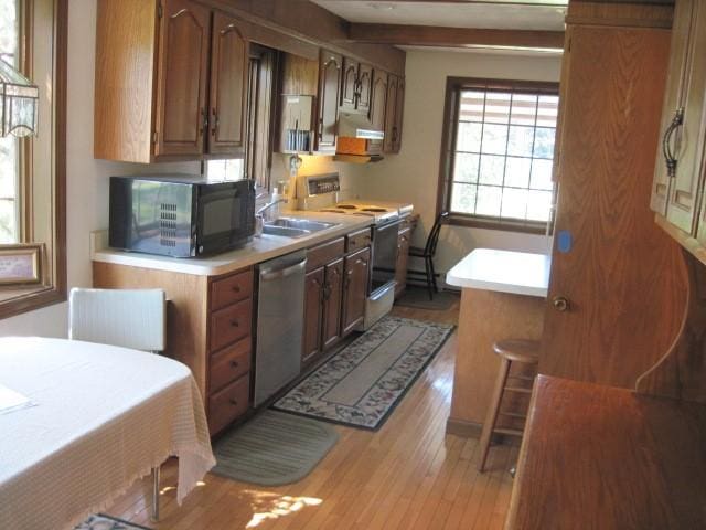 kitchen with stainless steel dishwasher, sink, beamed ceiling, light hardwood / wood-style floors, and range with electric stovetop