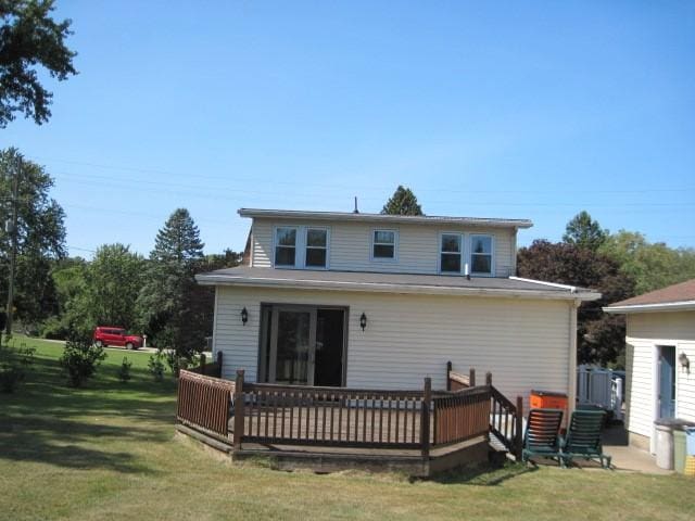 rear view of property with a wooden deck and a yard