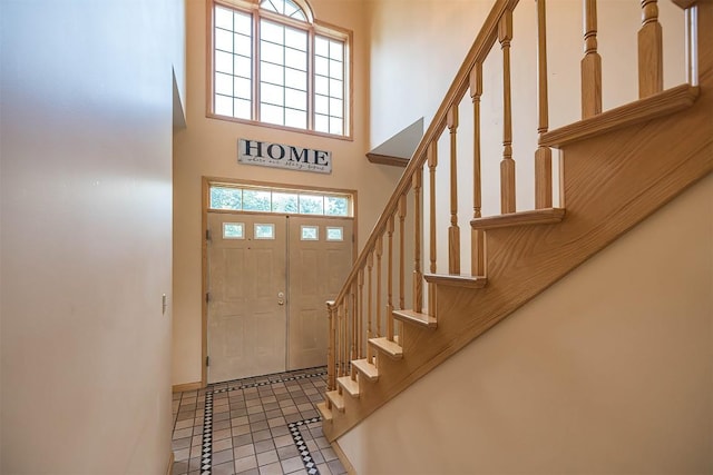4031 Zimmerly Rd, Erie, PA 16506 - foyer with stairway, a high ceiling, inlaid floor details, and light tile patterned flooring