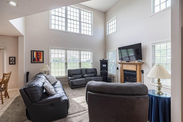 6018 Pebble Creek Dr, Fairview, PA 16415 - tiled living area with a towering ceiling, healthy amount of natural light, a glass covered fireplace, and baseboards