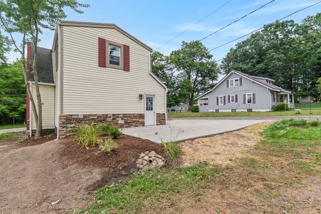 20527 Baird Rd, Meadville, PA 16335 - view of property exterior with concrete driveway, stone siding, and a shingled roof