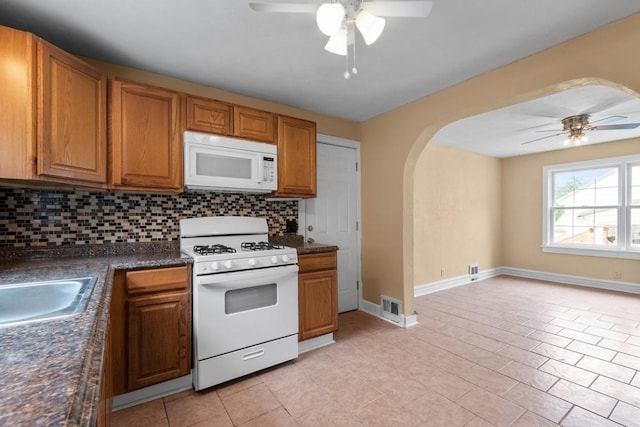 20527 Baird Rd, Meadville, PA 16335 - kitchen featuring ceiling fan, white appliances, dark countertops, and arched walkways