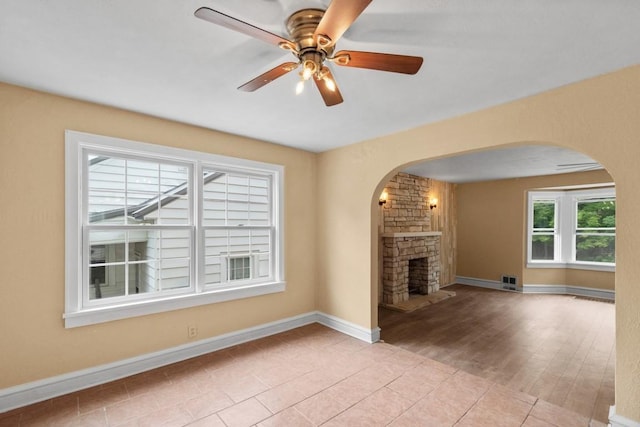 20527 Baird Rd, Meadville, PA 16335 - unfurnished living room with arched walkways, a fireplace, and a ceiling fan