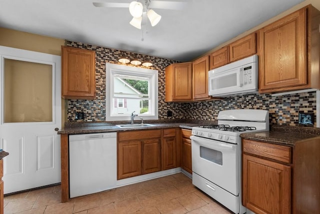 20527 Baird Rd, Meadville, PA 16335 - kitchen featuring white appliances, dark countertops, brown cabinetry, backsplash, and a ceiling fan
