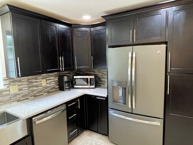 1742 W Gore Rd, Millcreek, PA 16509 - kitchen with stainless steel appliances, tasteful backsplash, recessed lighting, light stone countertops, and dark cabinetry