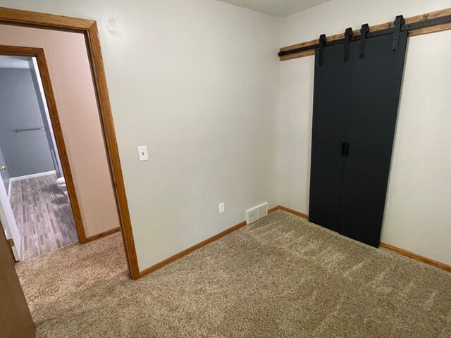 1742 W Gore Rd, Millcreek, PA 16509 - spare room featuring a barn door and carpet