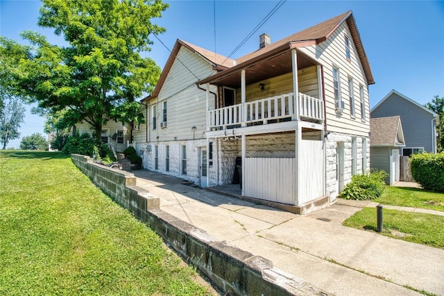 352 E 2nd St, Erie, PA 16507 - view of side of property with a yard, stone siding, and a balcony