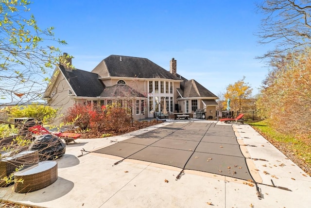 back of house featuring a patio and a covered pool