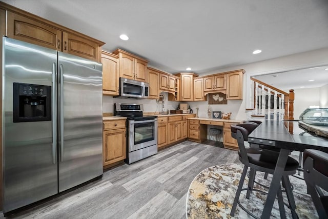 kitchen featuring light hardwood / wood-style floors, sink, and appliances with stainless steel finishes