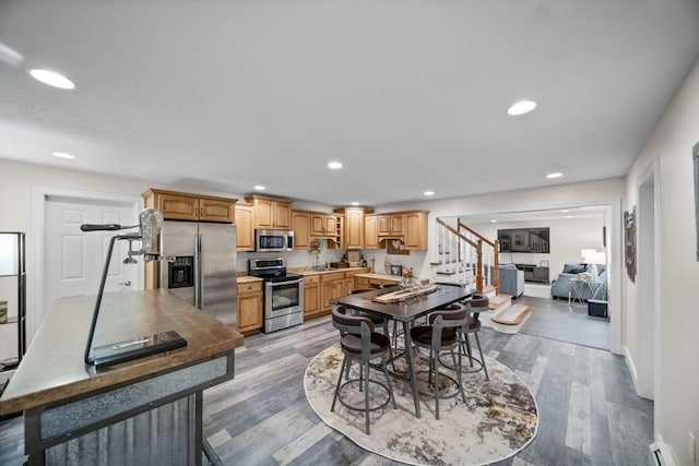 dining space with a baseboard radiator, light hardwood / wood-style flooring, and sink