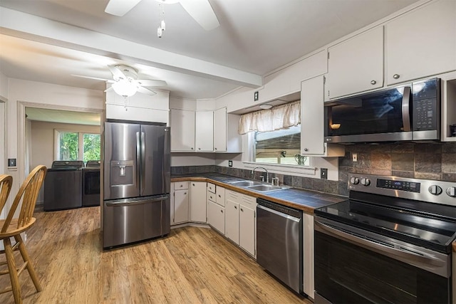 454 Orchard Beach Rd, North East, PA 16428 - kitchen featuring stainless steel appliances, a ceiling fan, washer and clothes dryer, light wood-style floors, and beam ceiling