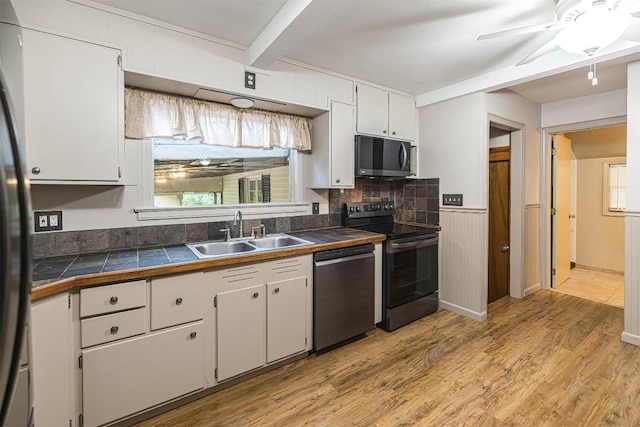 454 Orchard Beach Rd, North East, PA 16428 - kitchen featuring stainless steel appliances, light wood finished floors, beam ceiling, white cabinetry, and a ceiling fan