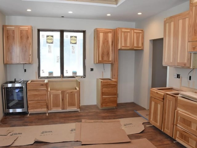 kitchen with dark wood-type flooring, recessed lighting, beverage cooler, and light brown cabinetry