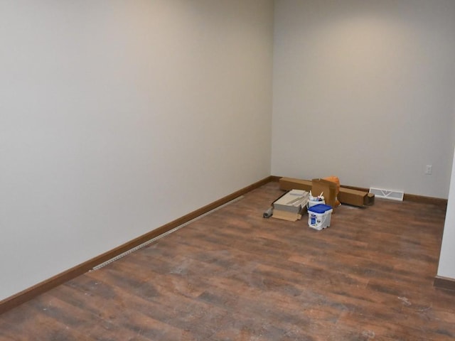 spare room featuring visible vents, baseboards, and wood finished floors