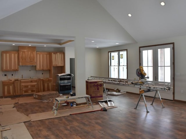 kitchen featuring baseboards, wood finished floors, light brown cabinets, high vaulted ceiling, and recessed lighting