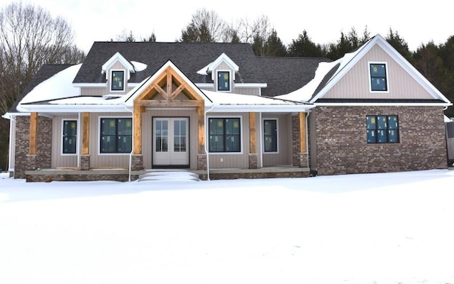 view of front of house featuring a porch, french doors, and brick siding