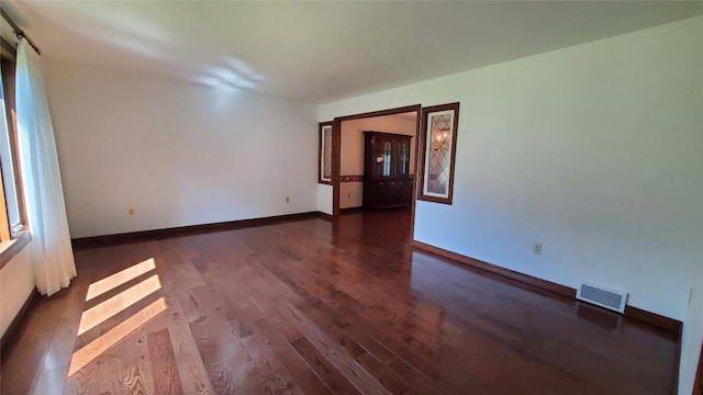 empty room featuring a barn door and dark hardwood / wood-style floors