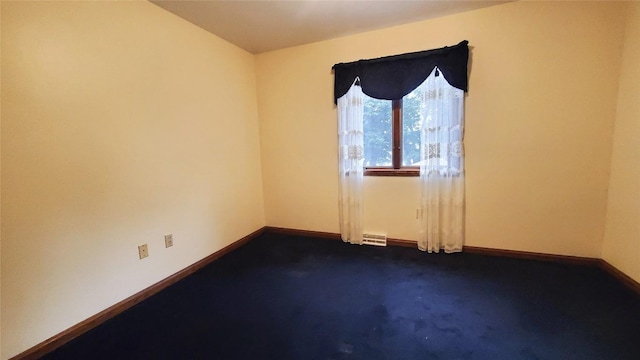 unfurnished room with dark carpet