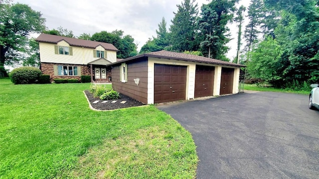 view of front of home featuring a garage, a front lawn, and an outdoor structure