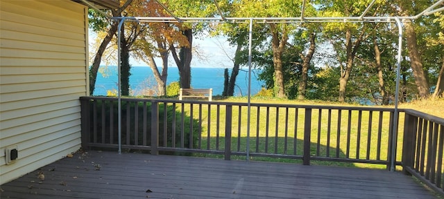 wooden terrace featuring a lawn and a water view