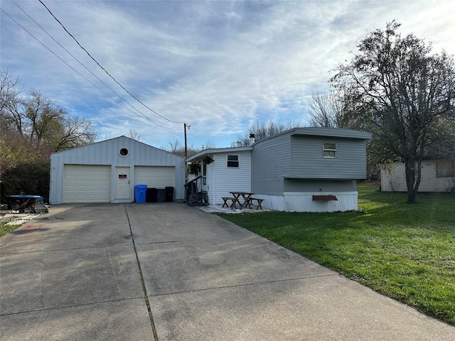 view of front of house featuring an outbuilding, a garage, and a front yard