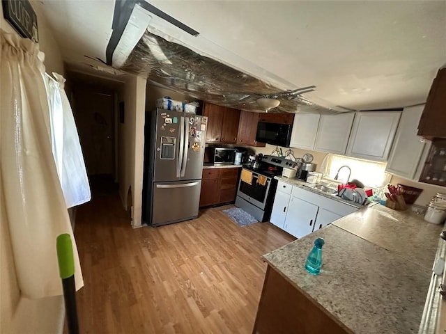 kitchen with white cabinetry, light hardwood / wood-style flooring, and appliances with stainless steel finishes