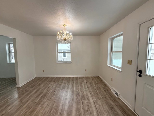 interior space featuring an inviting chandelier and dark hardwood / wood-style flooring