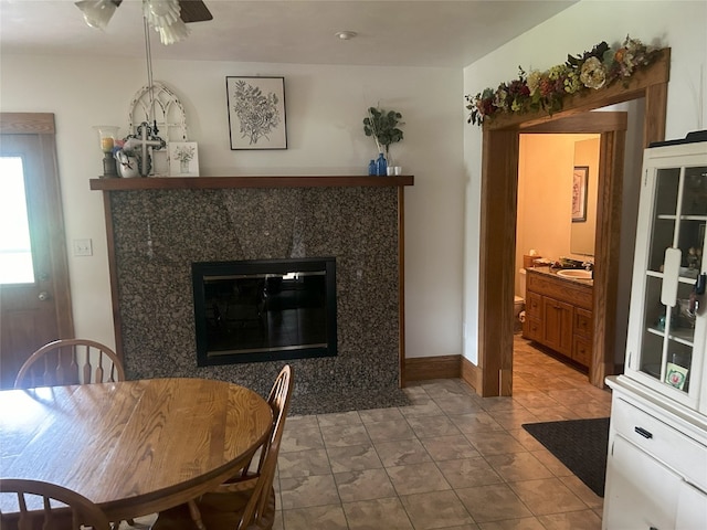 tiled dining room with ceiling fan and sink