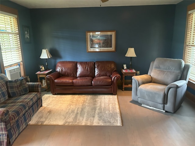 living room featuring ceiling fan, plenty of natural light, cooling unit, and wood-type flooring