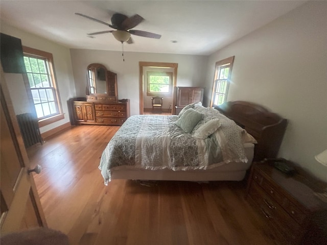 bedroom with multiple windows, light wood-type flooring, and ceiling fan