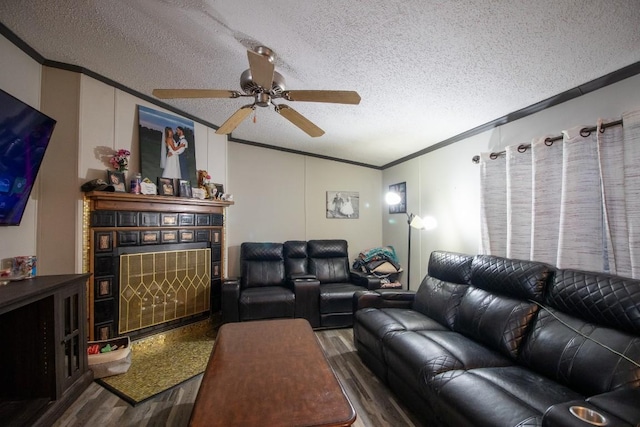 living room with lofted ceiling, hardwood / wood-style flooring, ceiling fan, ornamental molding, and a textured ceiling