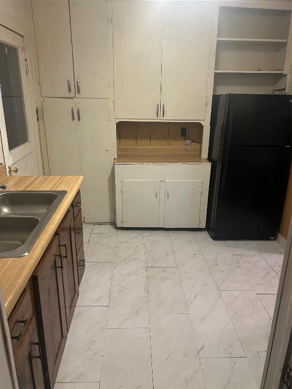 kitchen featuring black refrigerator and sink