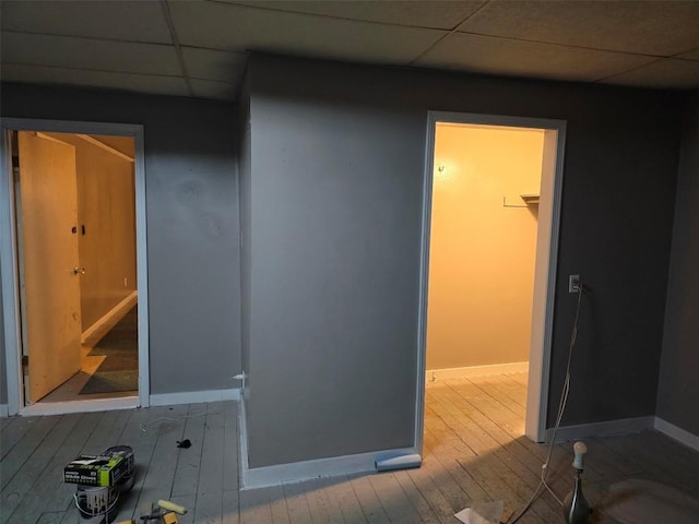 interior space featuring a drop ceiling and hardwood / wood-style flooring