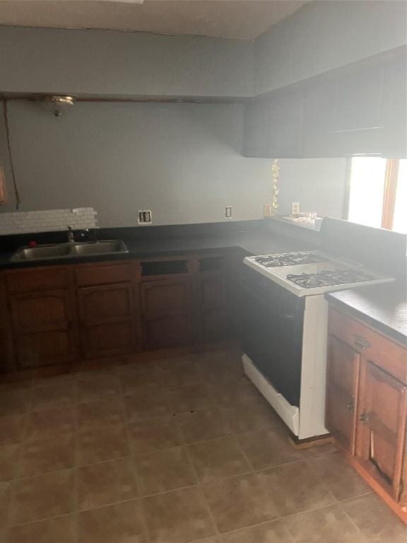 kitchen featuring white electric stove and sink