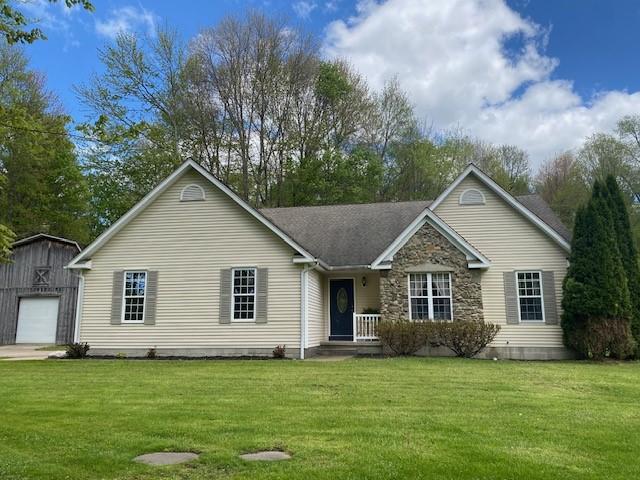 2156 Depot St, Waterford, PA 16441 - view of front of house with an outdoor structure, a front lawn, a detached garage, and stone siding