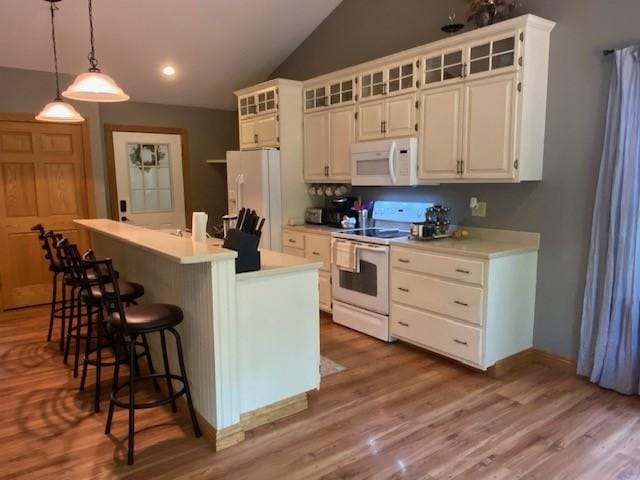 2156 Depot St, Waterford, PA 16441 - kitchen with white appliances, a center island with sink, a breakfast bar area, white cabinets, and light countertops