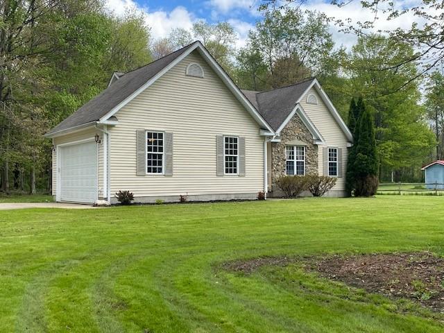 2156 Depot St, Waterford, PA 16441 - view of property exterior with driveway, a yard, an attached garage, and stone siding
